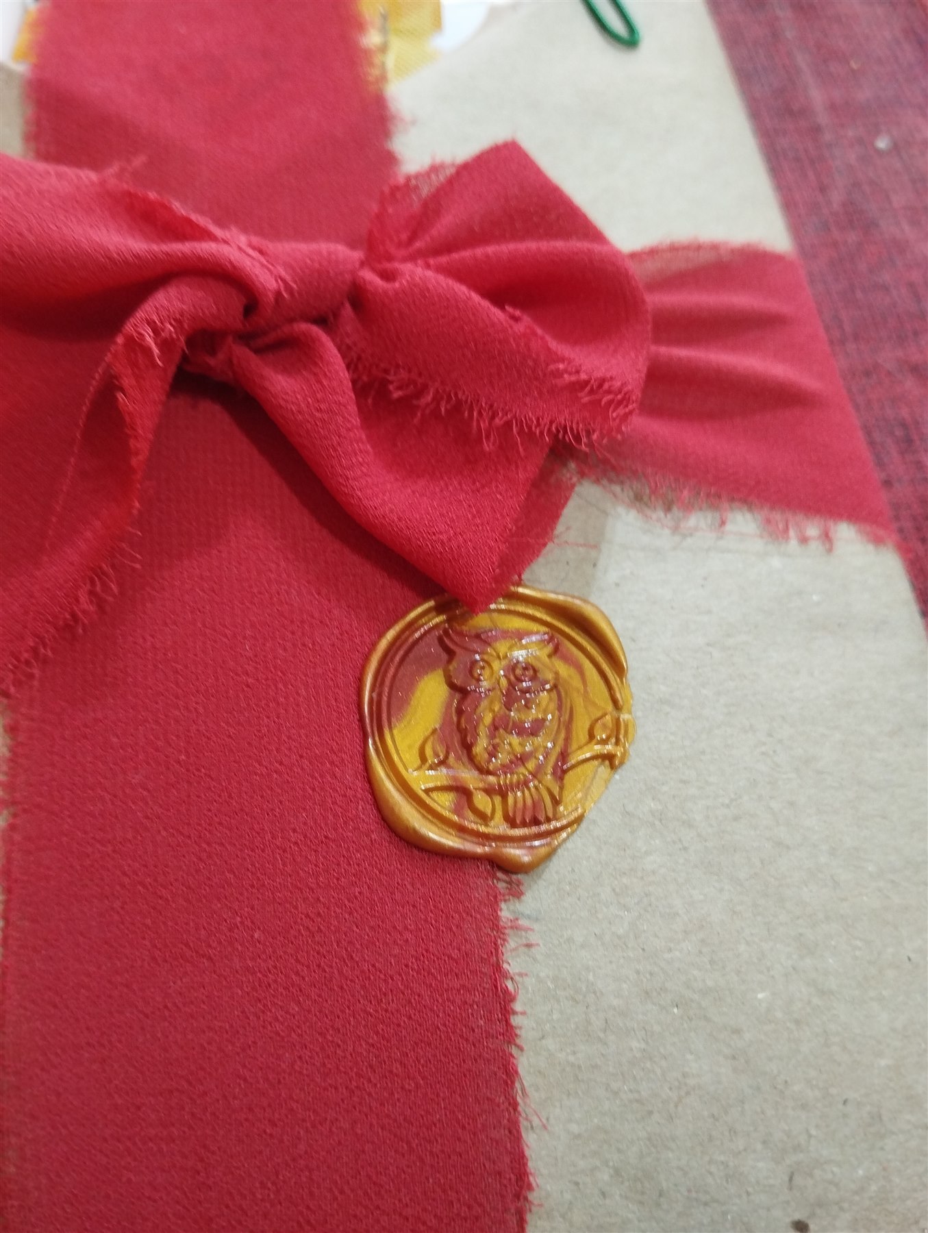 Embalagem de tecido com laço vermelho e selo de cera artesanal